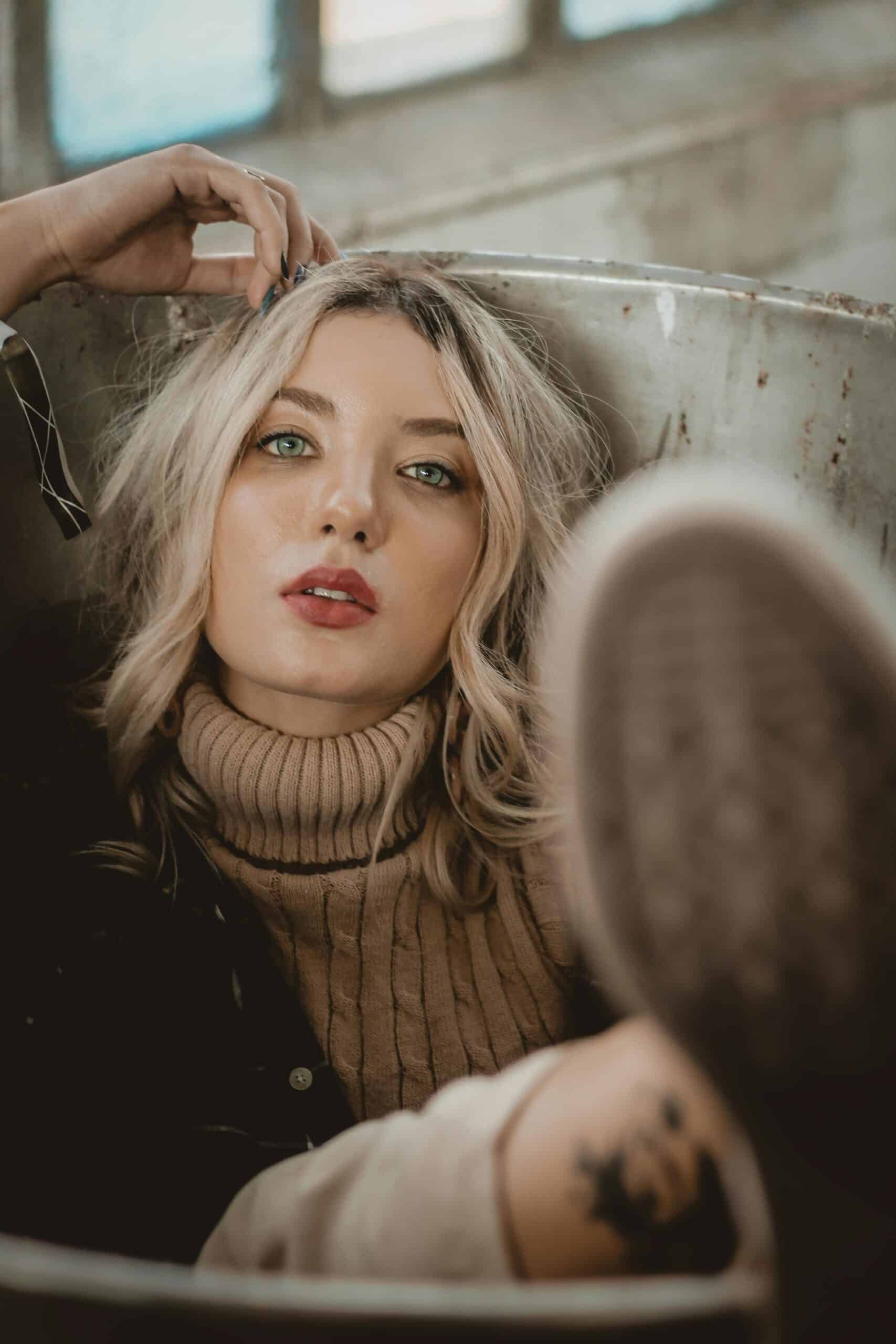 Portrait of a woman in a turtleneck posing in an industrial setting, exuding style and confidence.